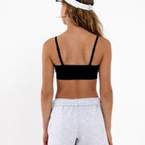 Back view of a girl wearing a black SASSH Essential training bra showing adjustable criss-cross straps — girls first bra, seamless training bra.