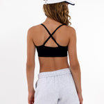 Close-up back view of a black SASSH Essential training bra showing adjustable straps and seamless underband — girls first bra.