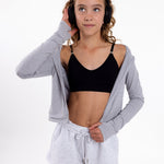 Girl wearing a black SASSH Essential training bra with seamless underband, front view — girls first bra for tweens.