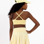 Close-up back view of a lemon yellow SASSH Essential training bra showing adjustable straps and seamless underband — girls first bra.