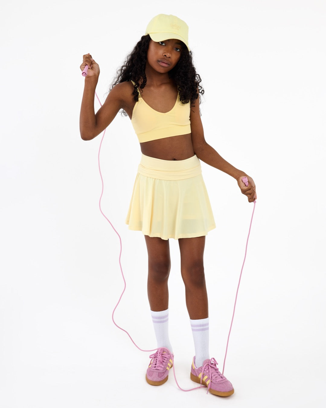 Girl wearing a lemon yellow SASSH Essential training bra in a complete outfit — first bra for tweens and teens.