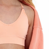 Close-up of a peach SASSH Essential training bra showing bow strap detail and seamless underband — girls seamless training bra, first bra.
