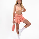 Girl wearing a peach SASSH Essential training bra in a complete outfit — seamless first bra for tweens and teens.