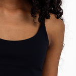 Close-up of a girl wearing a black sports bra with adjustable straps, and a pullover style.