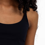 Close-up of a girl wearing a black sports bra with adjustable straps, and a pullover style.