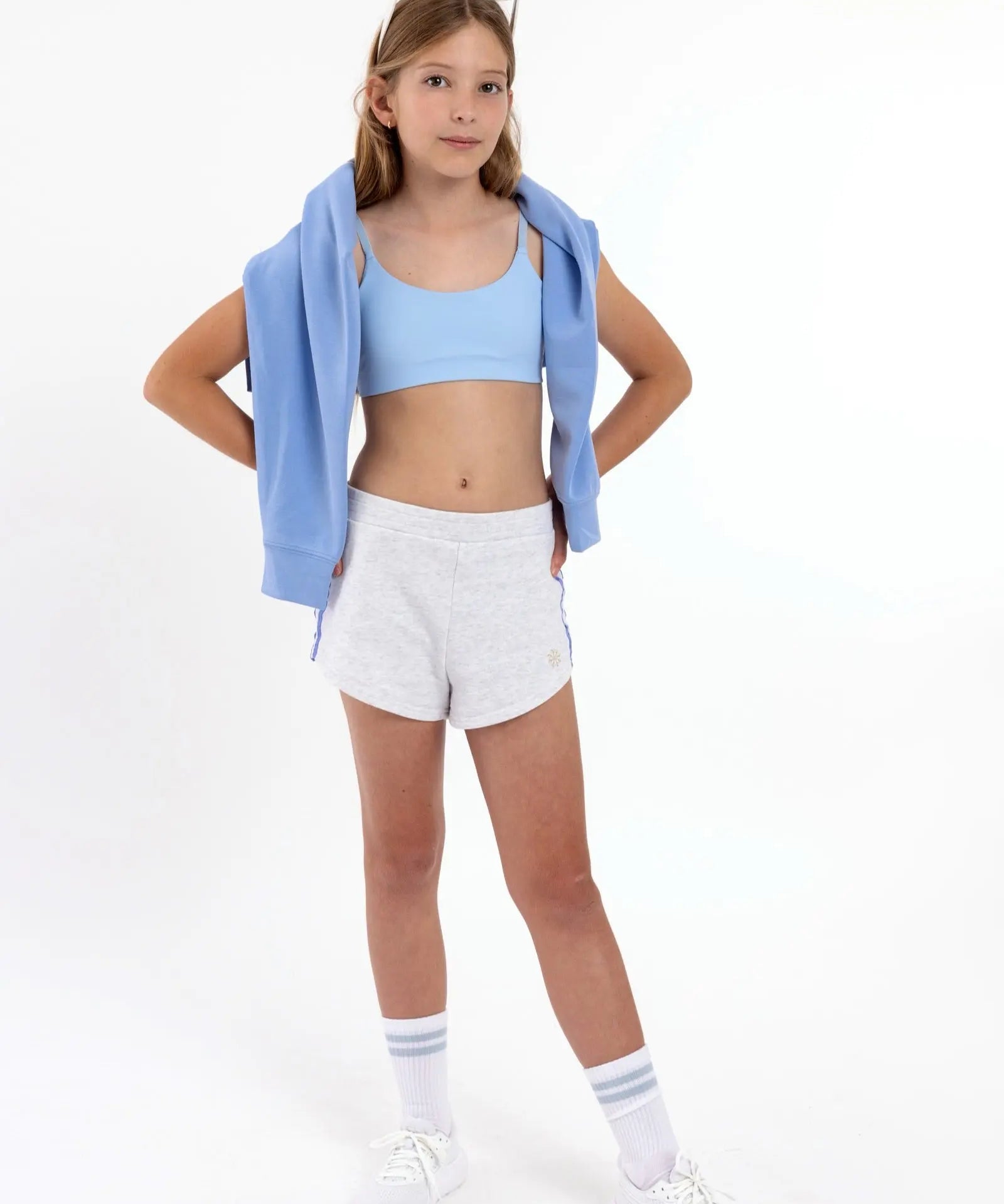 Girl wearing a light blue first scoop sports bra with adjustable straps, and a pullover style.