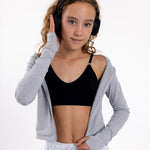 Girl listening to music wearing a black training bra with a seamless underband and adjustable straps.
