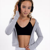 Girl listening to music wearing a black training bra with a seamless underband and adjustable straps.