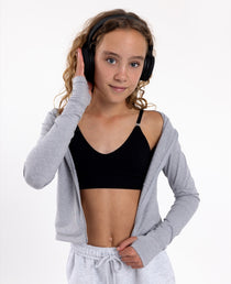 Girl listening to music wearing a black training bra with a seamless underband and adjustable straps.